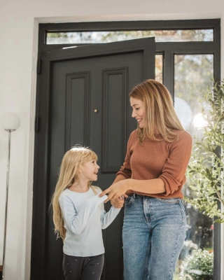 Mutter mit Tochter im Eingang des Hauses.